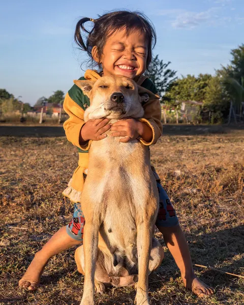 Een meisje knuffelt haar hond buiten